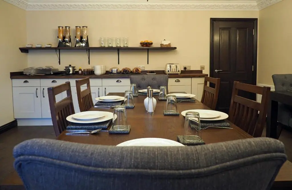 a table with plates and glasses on it in a kitchen at Appin House B&B in Fort Augustus