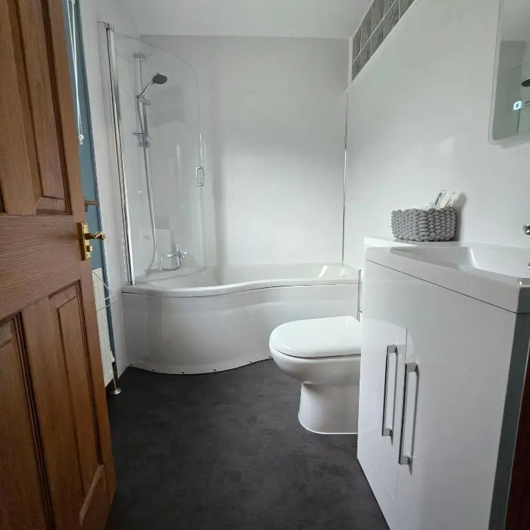 a bathroom with a toilet and a tub and a sink at Dail Daraich in Munlochy