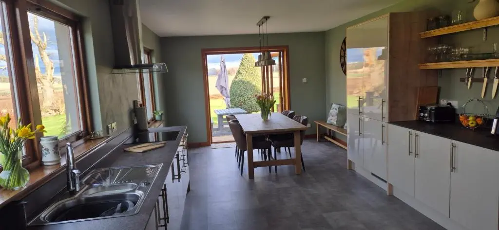a kitchen with a sink and a table in it at Dail Daraich in Munlochy