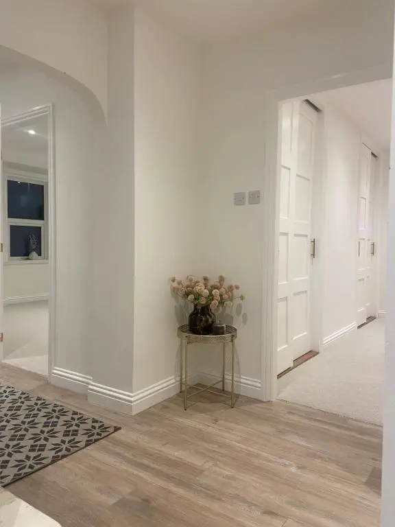 a hallway with a vase of flowers on a table at Halfred House in Wick