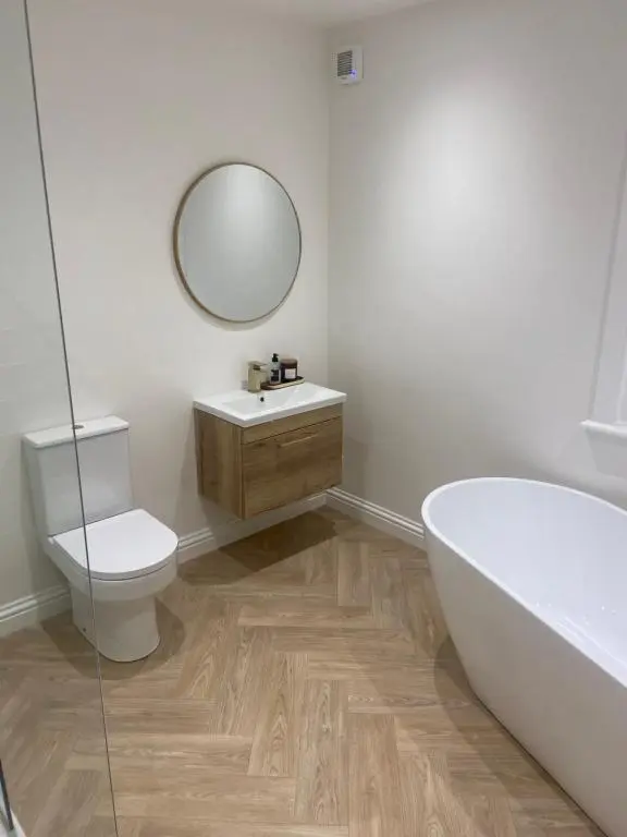 a bathroom with a tub and a toilet and a sink at Halfred House in Wick