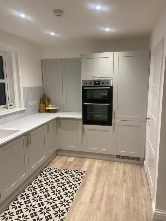 a kitchen with white cabinets and a black oven at Halfred House in Wick
