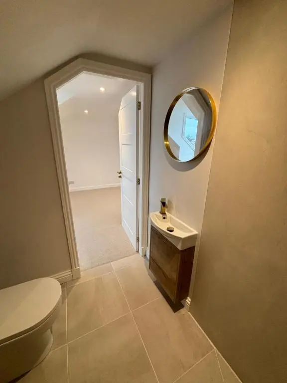 a bathroom with a toilet and a mirror at Halfred House in Wick