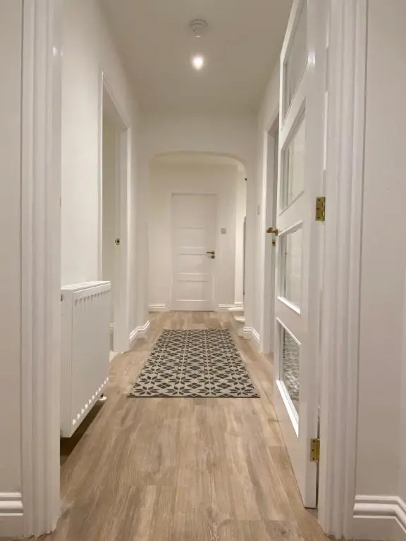 an empty hallway with white walls and wood floors at Halfred House in Wick