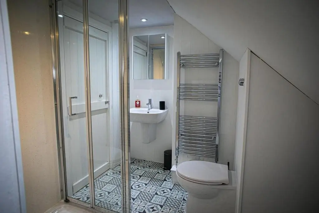 a bathroom with a shower and a toilet and a sink at Castle Grant - 4 Bed Cottage in Gardenstown in Gardenstown