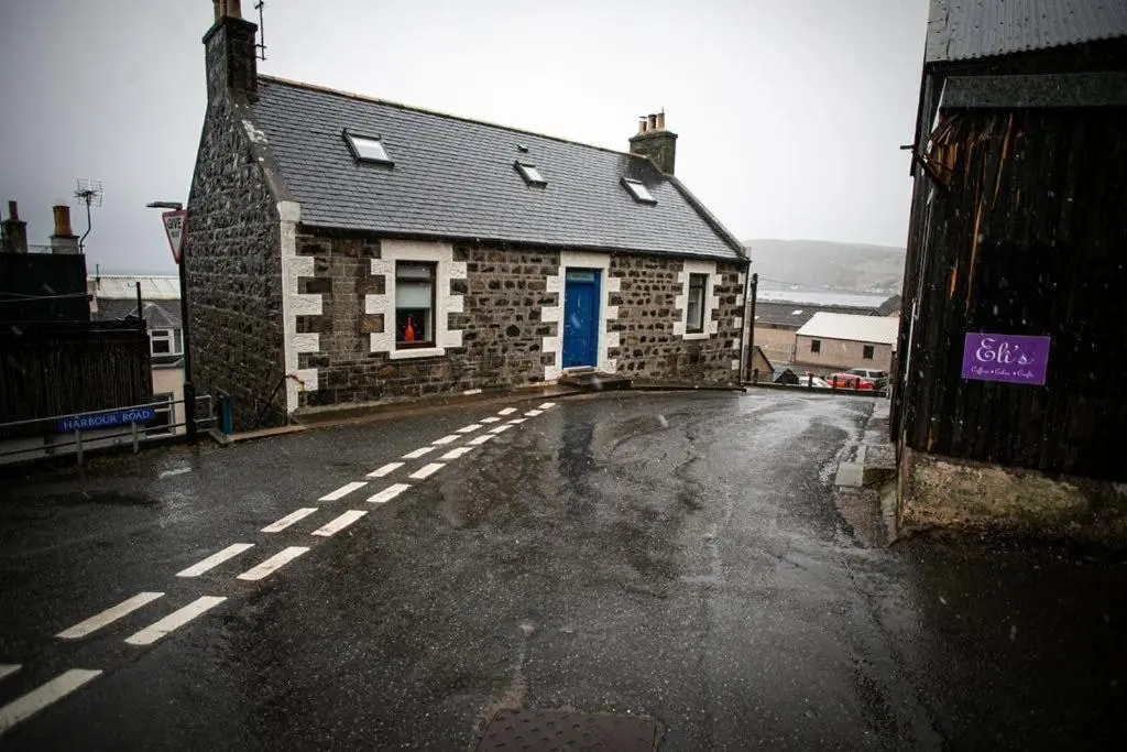 an empty street in front of a stone building at Castle Grant - 4 Bed Cottage in Gardenstown in Gardenstown
