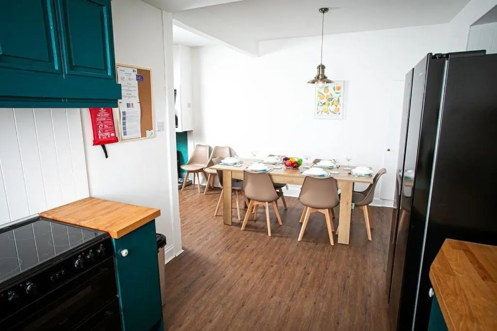 a kitchen with a table and chairs in a kitchen at Castle Grant - 4 Bed Cottage in Gardenstown in Gardenstown