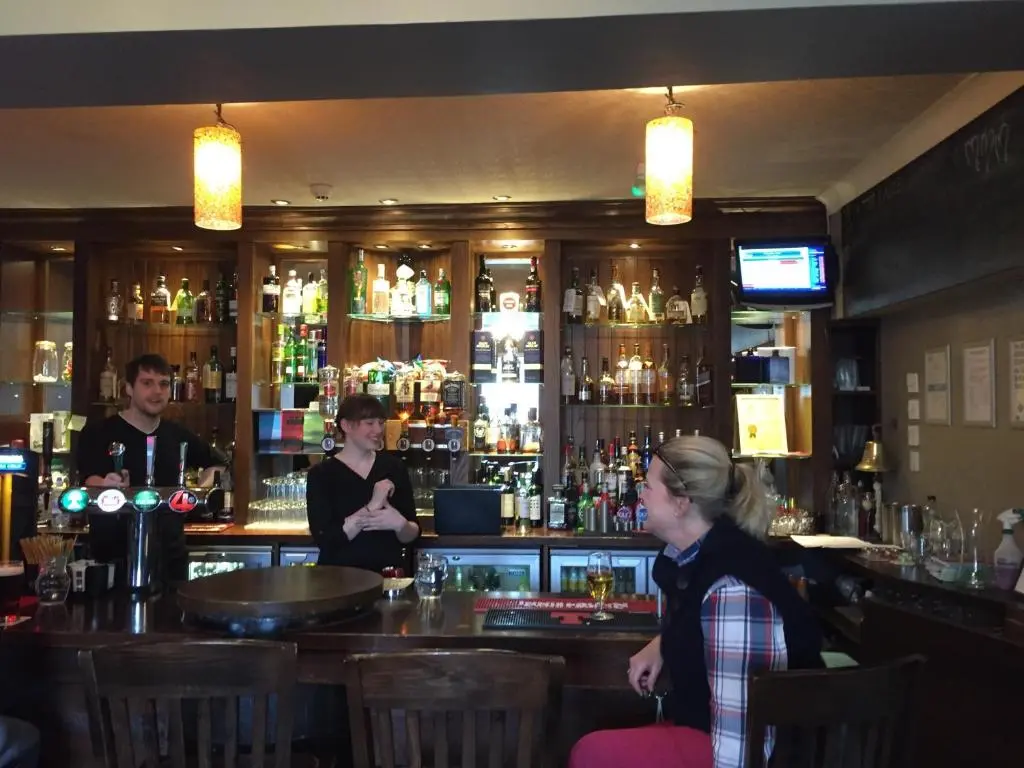 a group of people standing at a bar at Eagle Hotel in Dornoch