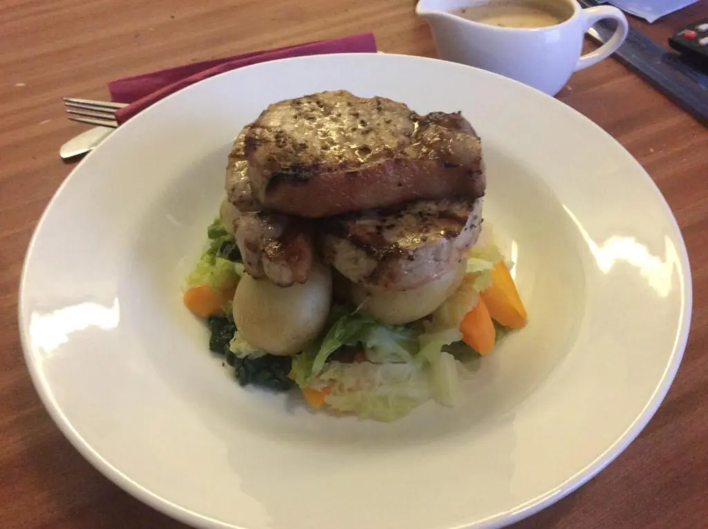 a white plate with a sandwich with vegetables and a cup of coffee at Eagle Hotel in Dornoch