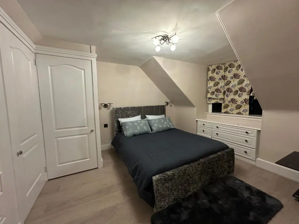 a bedroom with a large bed and a white door at 3 Bed Cottage Sleeps 2 with Parking Garden & Wifi in Aberdeen