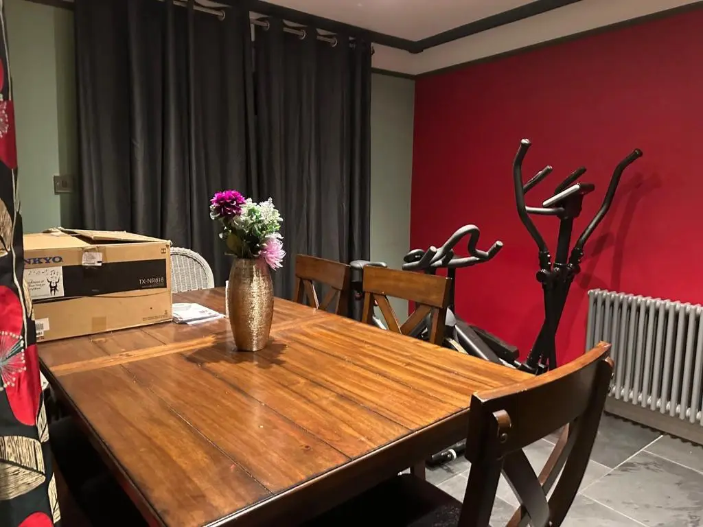 a wooden table with a vase of flowers on it at 3 Bed Cottage Sleeps 2 with Parking Garden & Wifi in Aberdeen