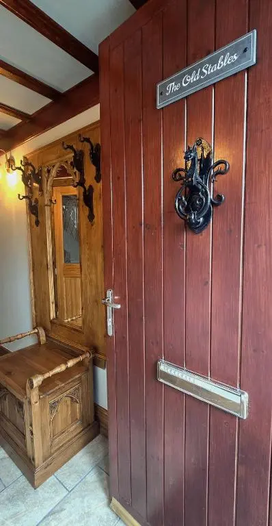 a wooden door in a room with a sign on it at The Old Stables in Fort Augustus