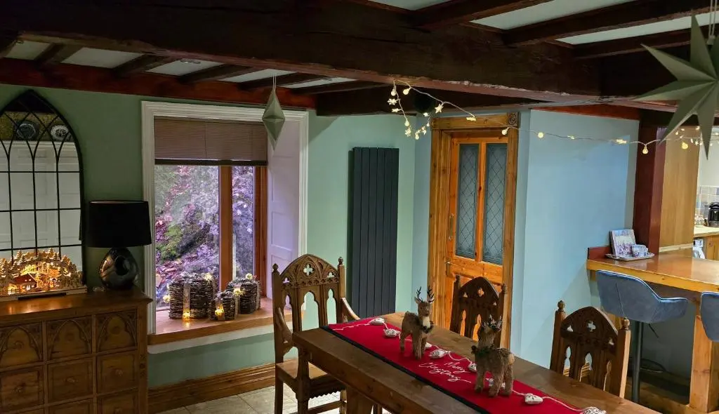 a dining room with a table with a red cloth on it at The Old Stables in Fort Augustus