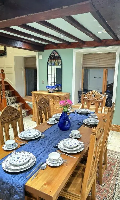 a dining room table with a blue vase on it at The Old Stables in Fort Augustus