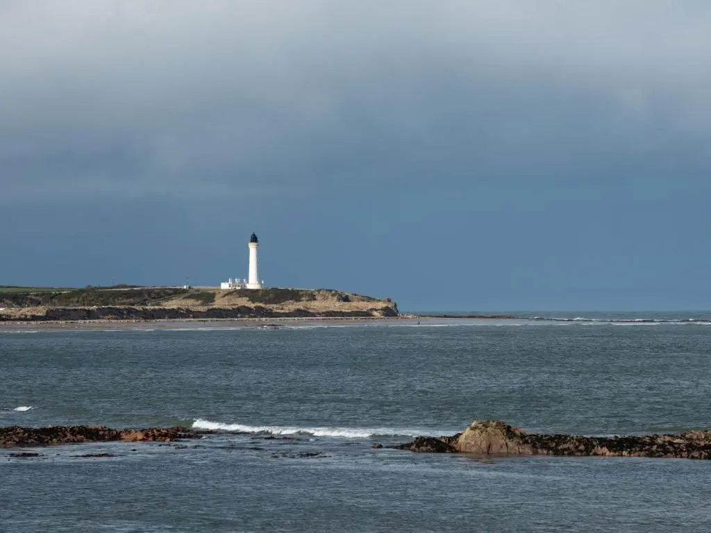 a body of water with a lighthouse in the distance at Apartment Harbour Nights Deluxe 7E by Interhome in Lossiemouth