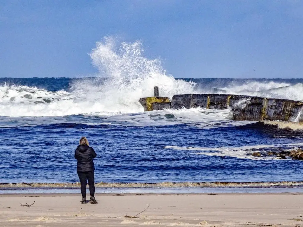 a woman standing on the beach watching the waves at Apartment Harbour Nights Deluxe 7E by Interhome in Lossiemouth
