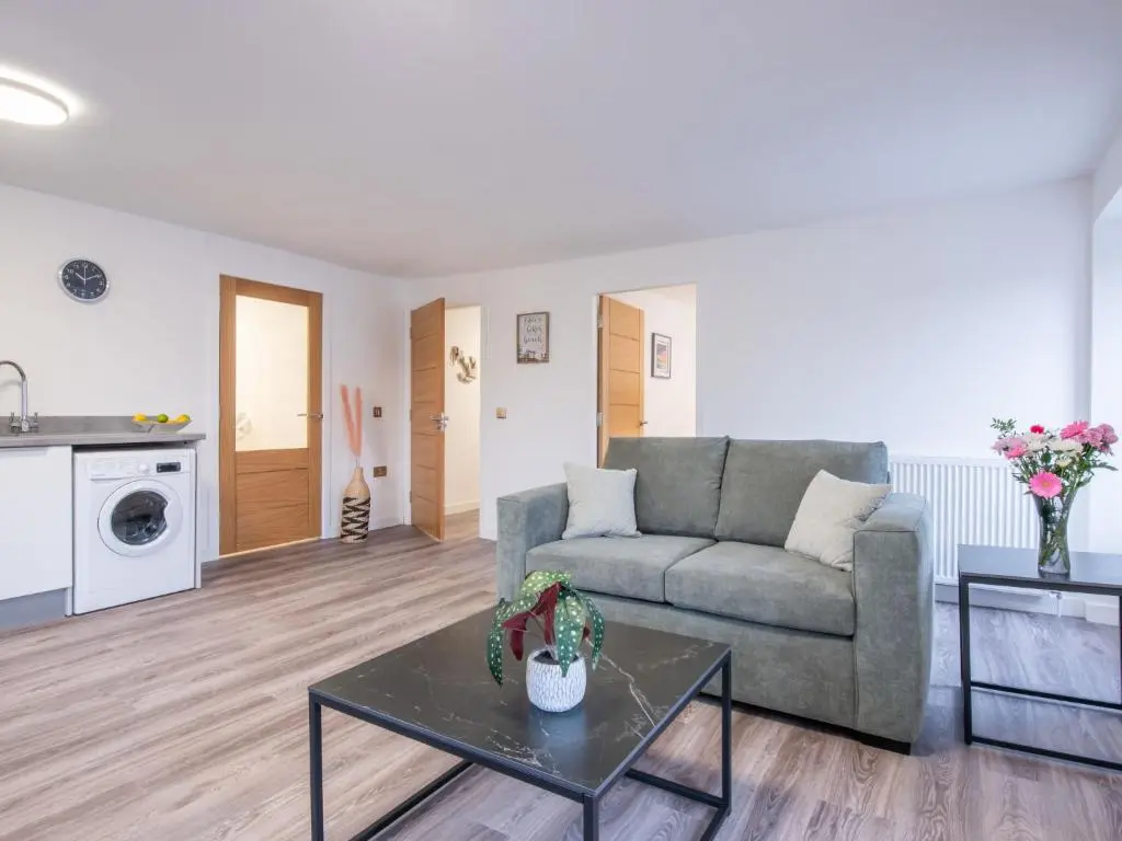 a living room with a couch and a table at Apartment Harbour Nights Deluxe 7F by Interhome in Lossiemouth