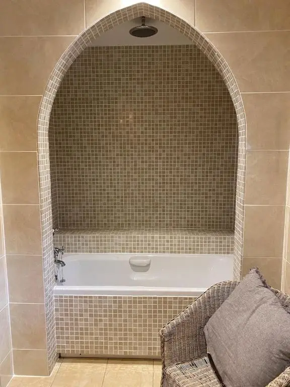 a bathroom with a bath tub with an arched niche at Spacious, cosy 6 bedroom house which sleeps 11 in Banchory