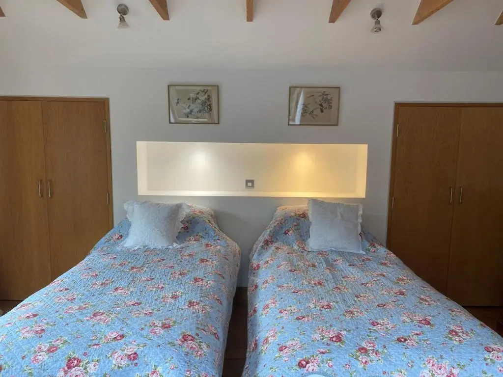 two beds sitting next to each other in a bedroom at Spacious, cosy 6 bedroom house which sleeps 11 in Banchory