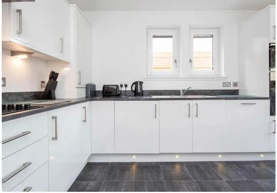 a white kitchen with white cabinets and a sink at 2 Bedroom Hedgefield Apartment 41-Free Parking in Inverness