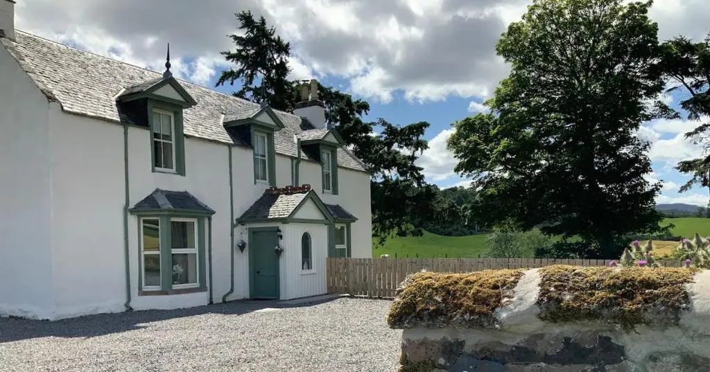 a white house with a green door and a fence at 3 Bed House near Loch Ness in Inverness