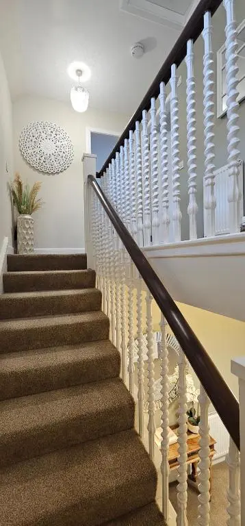 a staircase in a home with white railings at 3 Bed House near Loch Ness in Inverness