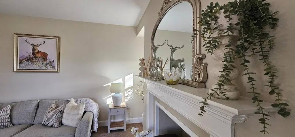 a living room with a fireplace and a mirror at 3 Bed House near Loch Ness in Inverness