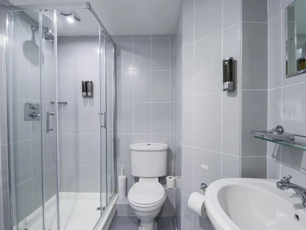 a bathroom with a toilet and a shower and a sink at Glenspey in Kingussie