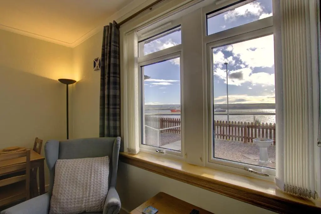 a bedroom with a window with a view of the ocean at Kavija, Invergordon in Invergordon