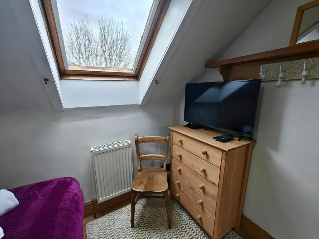 a bedroom with a tv on a dresser and a window at 3 Bed in Aviemore oc-s30815 in Aviemore