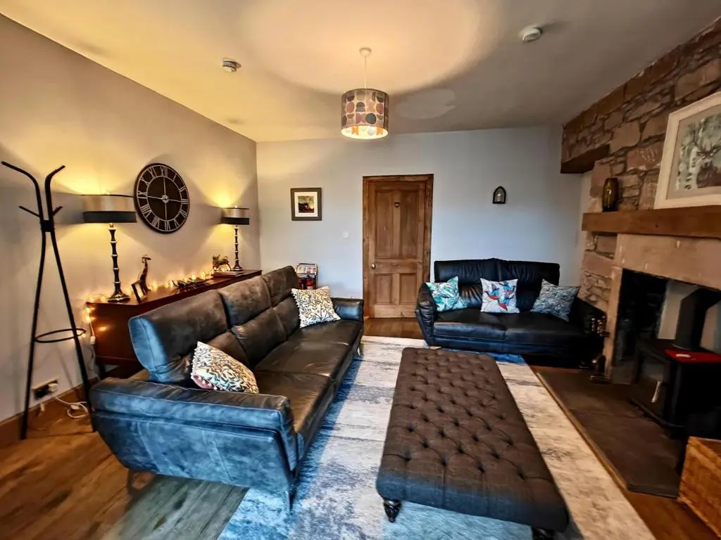 a living room with a leather couch and a fireplace at 3 Bed in Aviemore oc-s30815 in Aviemore