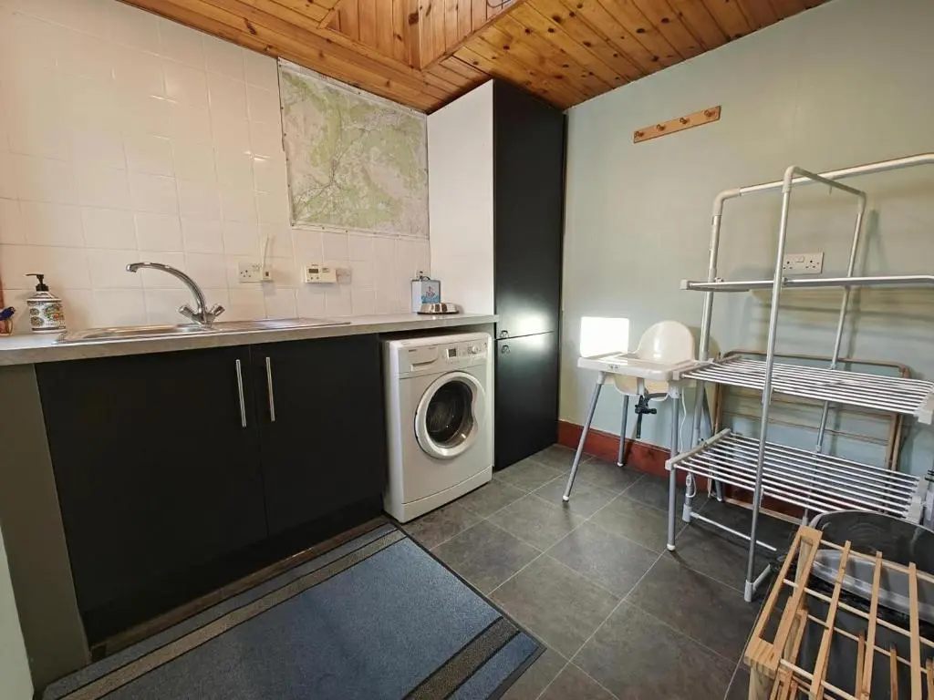 a kitchen with a washing machine and a sink at 3 Bed in Aviemore oc-s30815 in Aviemore