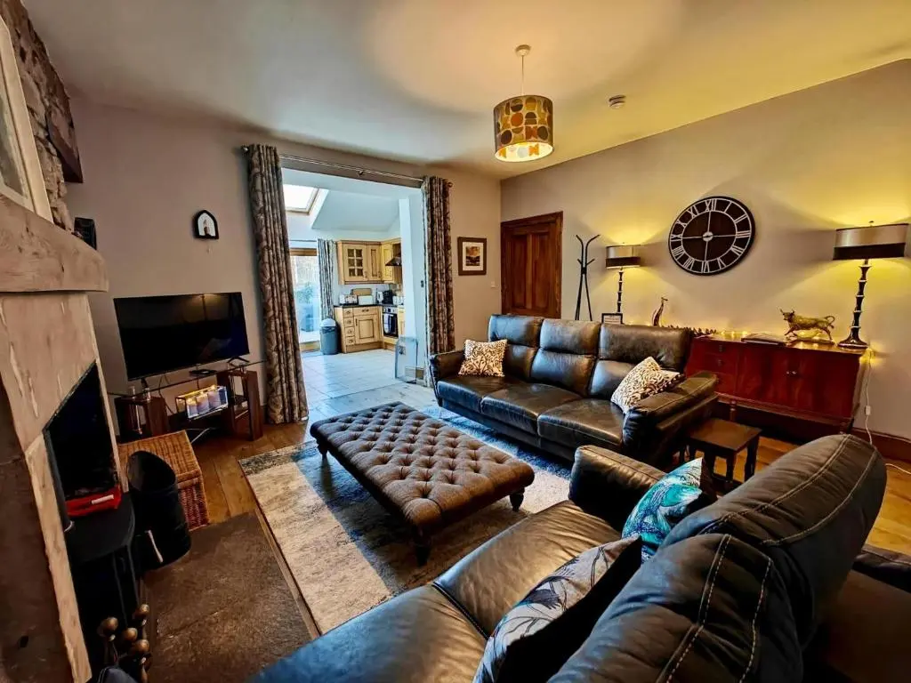 a living room with leather couches and a television at 3 Bed in Aviemore oc-s30815 in Aviemore