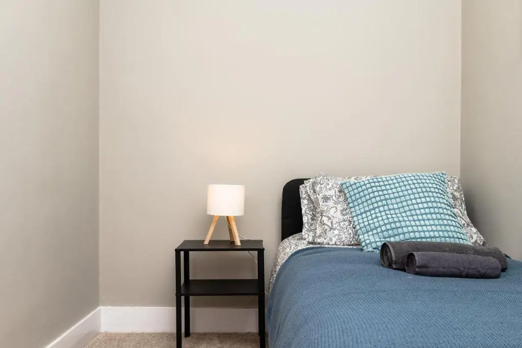 a bedroom with a bed and a lamp on a table at 2 Bedroom Flat - Free Parking - by Holiday Homes in Inverurie