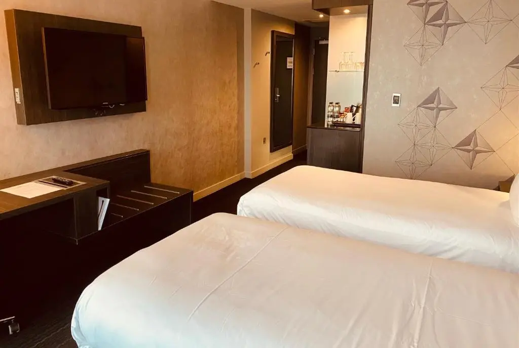 a hotel room with two beds and a flat screen tv at Crowne Plaza Aberdeen Airport by IHG in Dyce