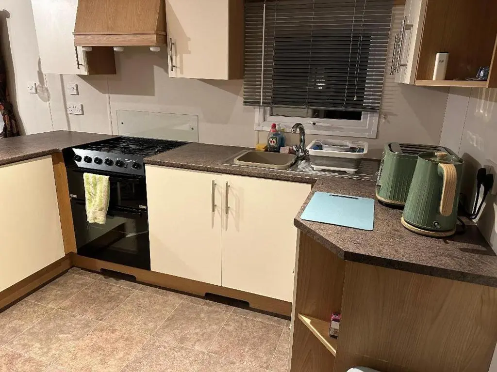 a small kitchen with a stove and a sink at Covesea View Silver Sands in Lossiemouth