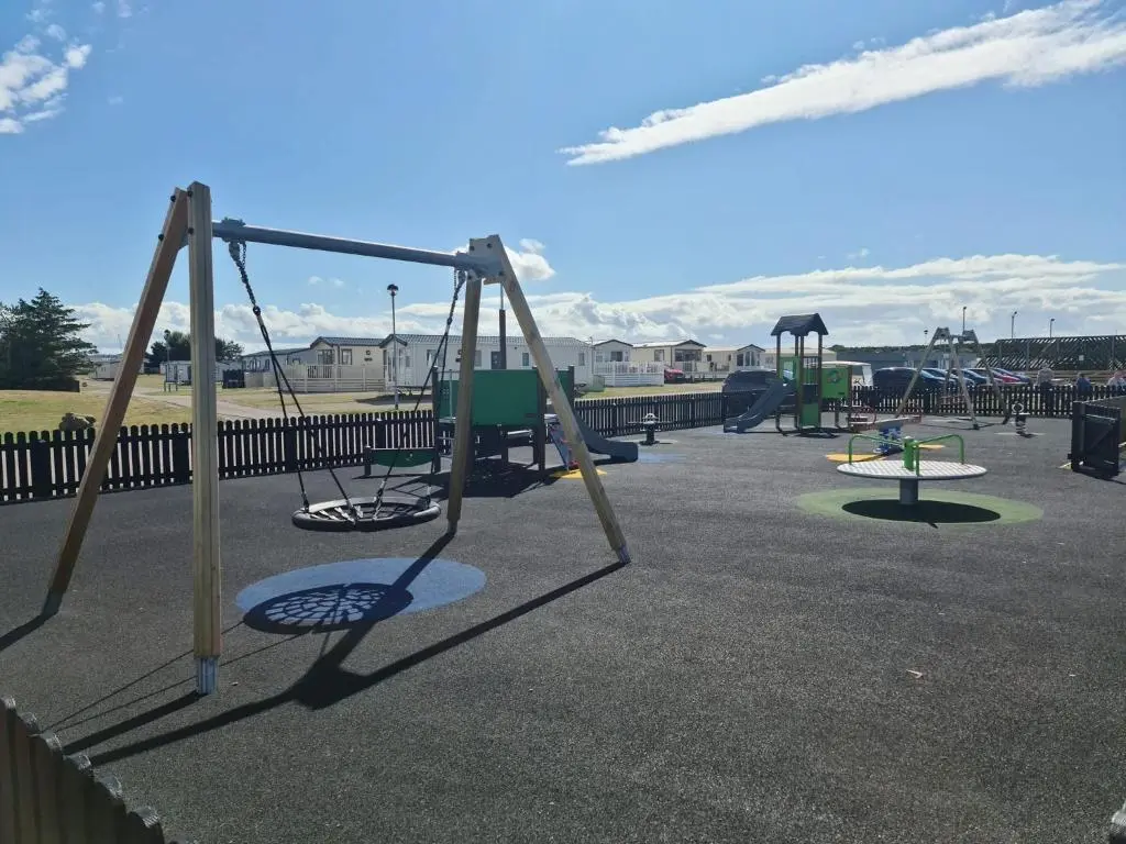 a group of swings in a playground at Covesea View Silver Sands in Lossiemouth
