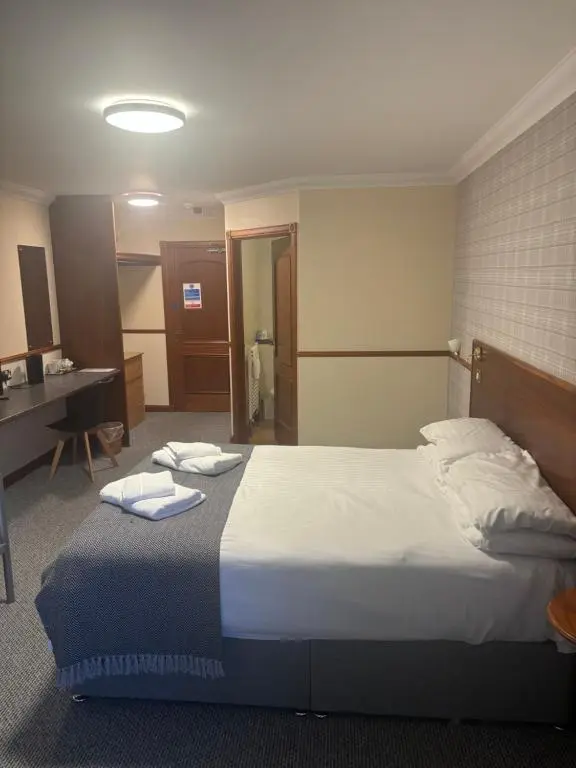 a bedroom with a large bed with two towels on it at Findlay's in Fraserburgh