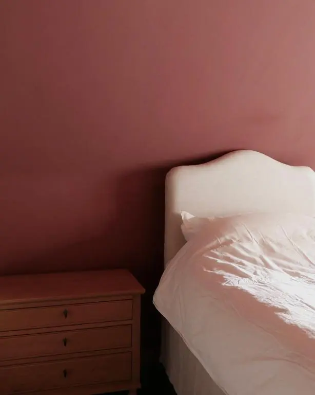 a bedroom with a white bed and a nightstand at Old school - Charming Historic Cottage for Seven in Ballater