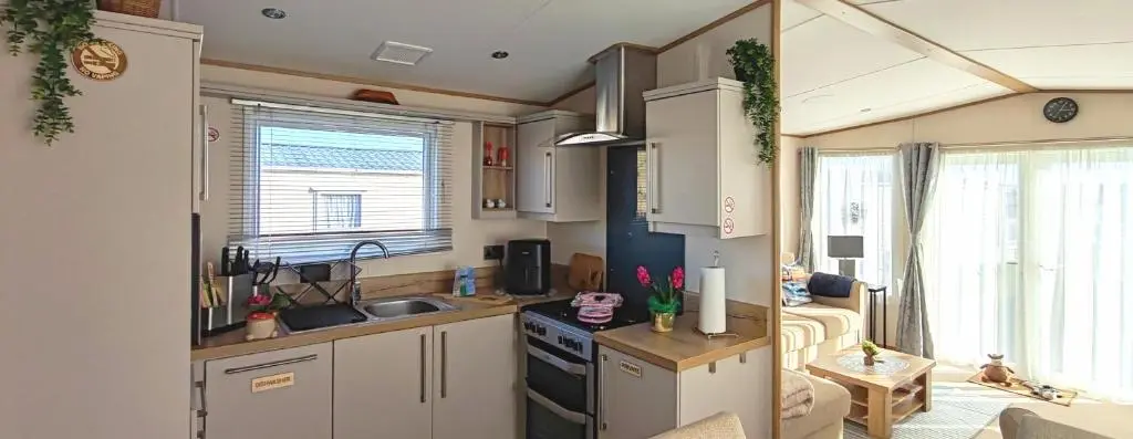 a kitchen with a sink and a stove top oven at Eagle's Den Caravan Holiday Retreat in Lossiemouth