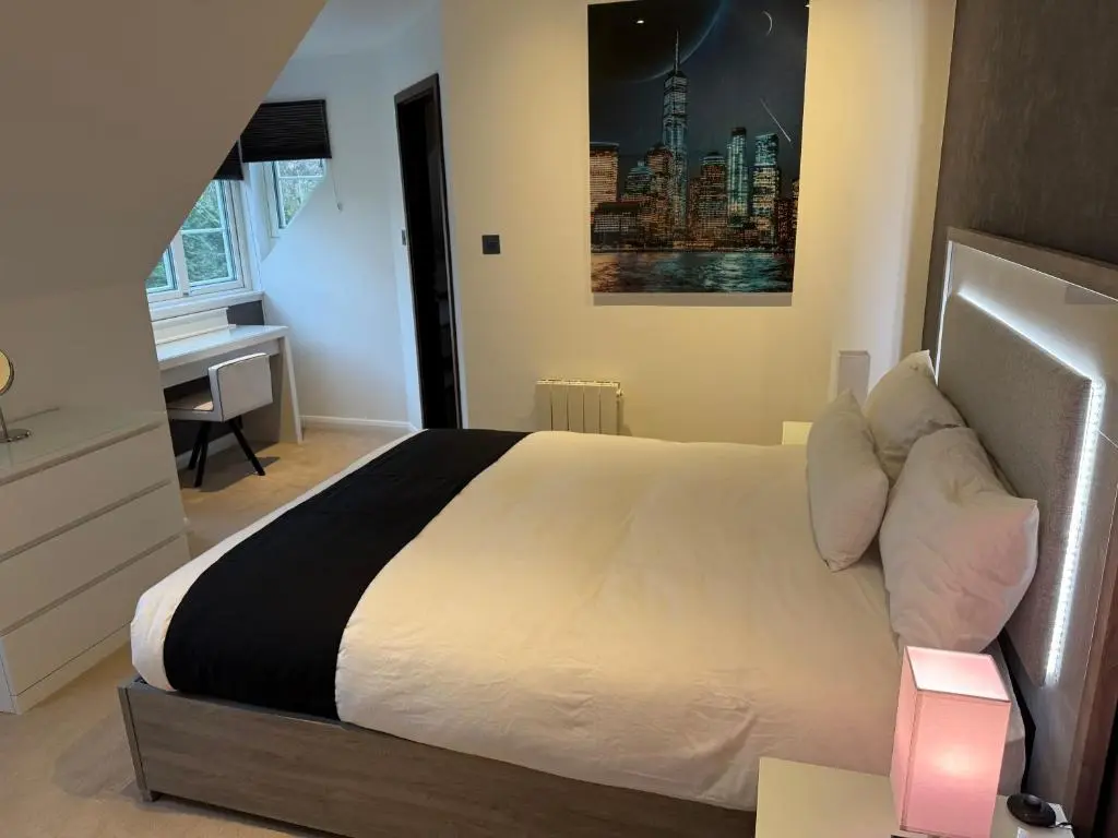 a bedroom with a large bed with a desk and a desk at Castlefield Penthouse in Inverness