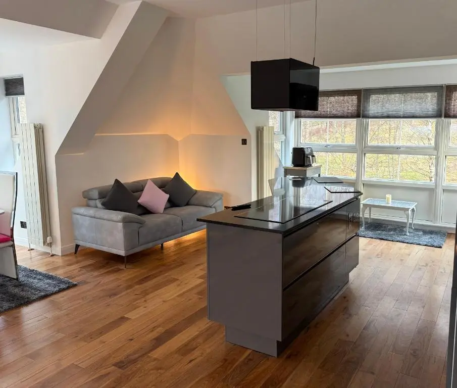a living room with a couch and a table at Castlefield Penthouse in Inverness