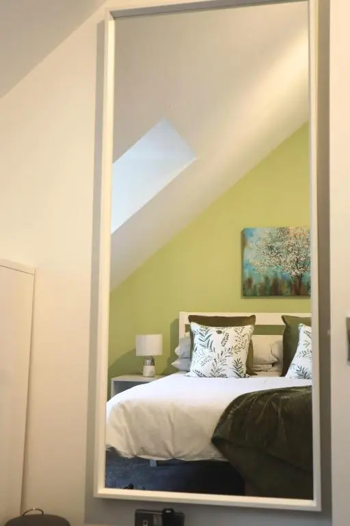 a mirror reflection of a bed in a bedroom at The Wee Heilan' Dram in Keith