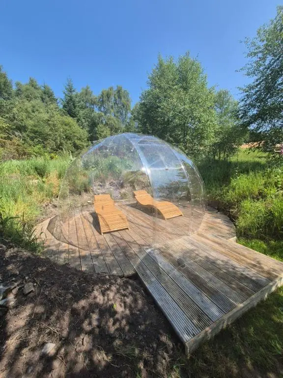 a dome with boxes inside of it in a field at Little Getaway in the Highlands, private sauna and stargazing geodome in Garve