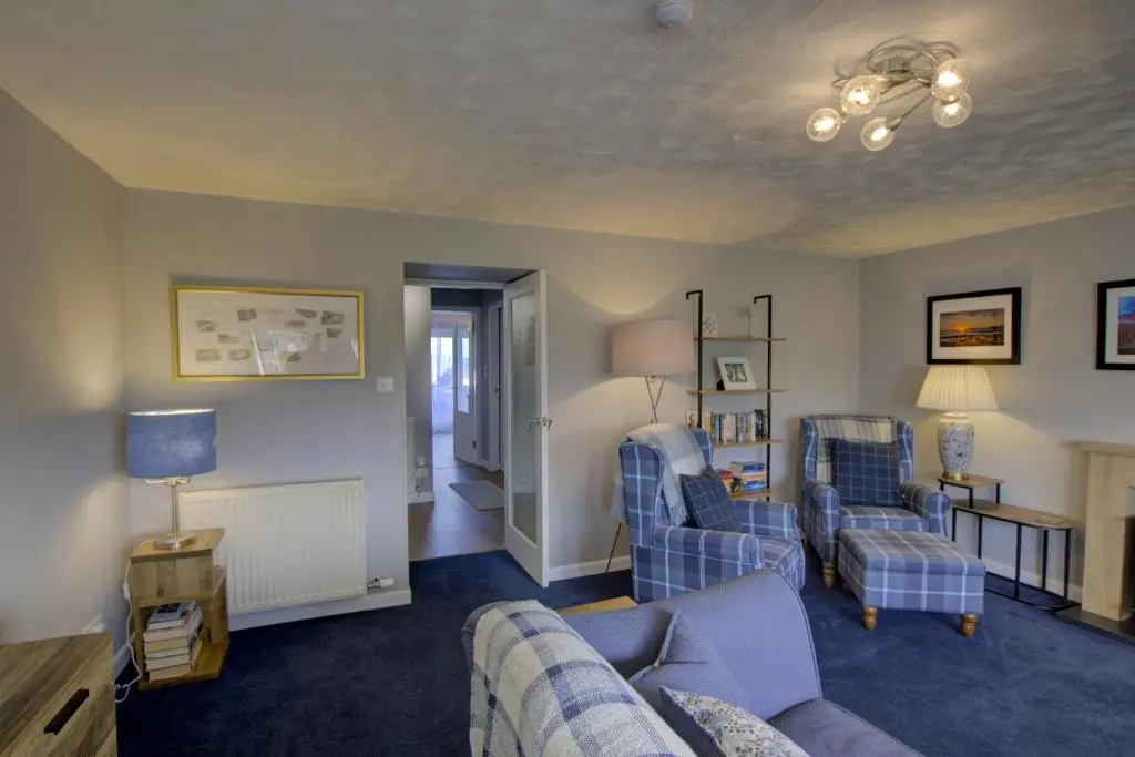 a living room with a couch and two chairs at Beach Croft, Brora in Brora