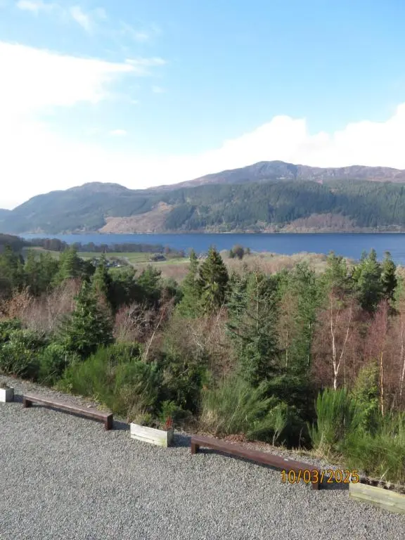 a view of a lake and mountains in the distance at The Loft at Log Ness in Inverness
