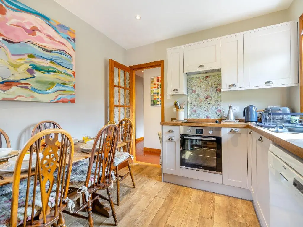 a kitchen with a table and a dining room at Clunie Dam Lodge in Blair Atholl