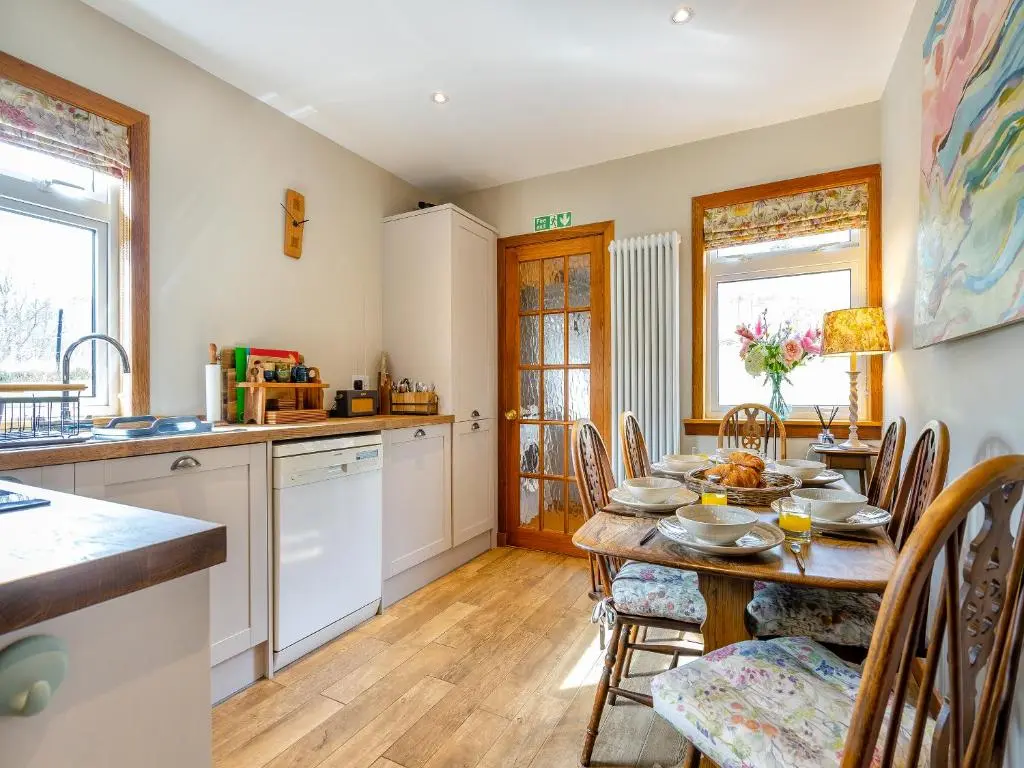 a kitchen and dining room with a table and chairs at Clunie Dam Lodge in Blair Atholl