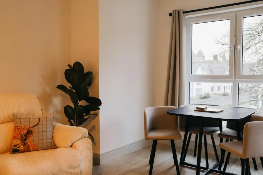 a living room with a table and a chair and a window at Luxurious Apartment in Inverness in Inverness