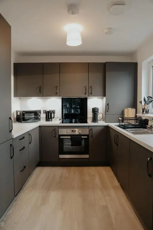a kitchen with brown cabinets and a stove top oven at Luxurious Apartment in Inverness in Inverness